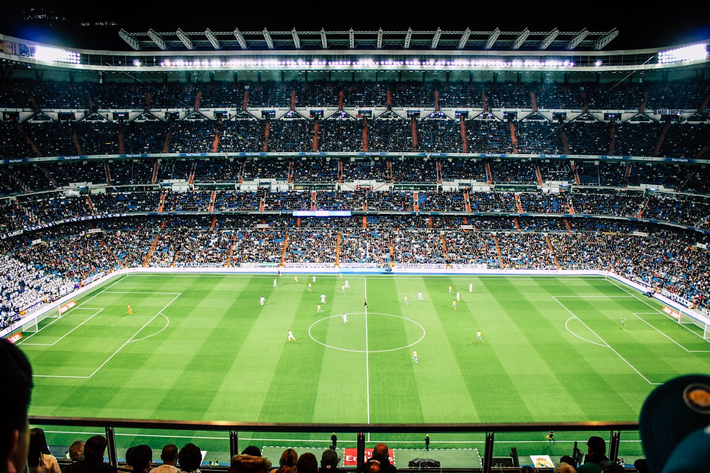 Floodlit football stadium filled with fans